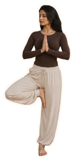A woman in tree pose, hands at heart centre, practicing a calm morning yoga sequence